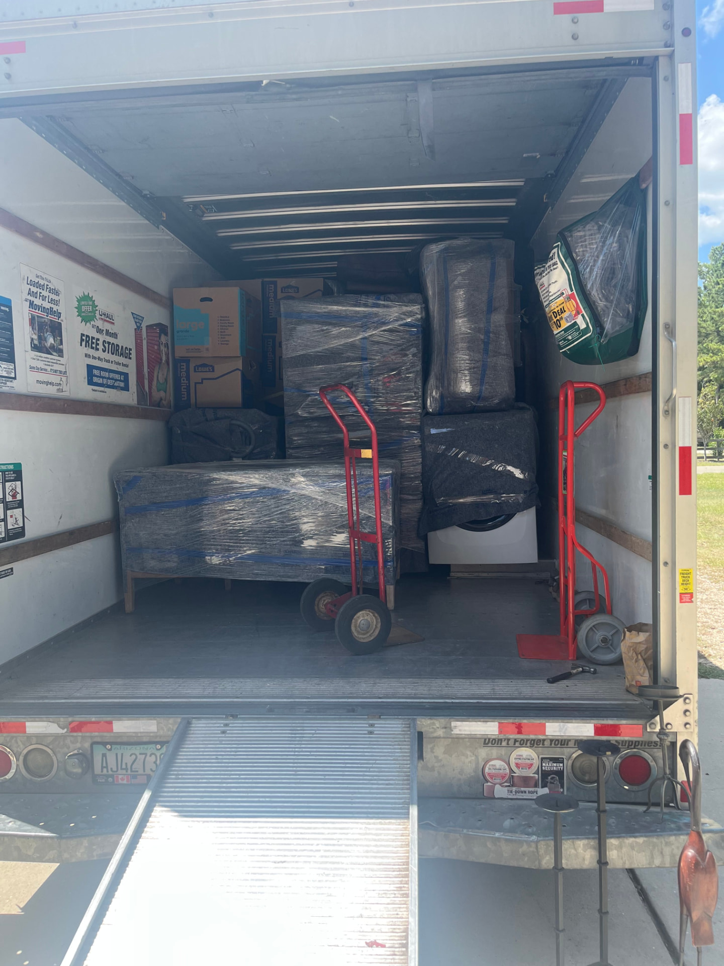 Fully loaded box truck with ramp down at a delivery