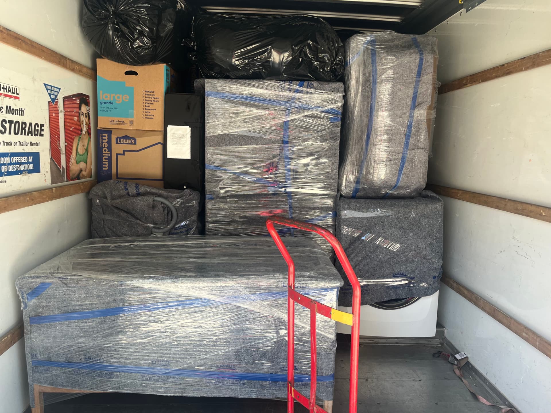Wrapped mattress, appliances and boxes packed tight in the truck