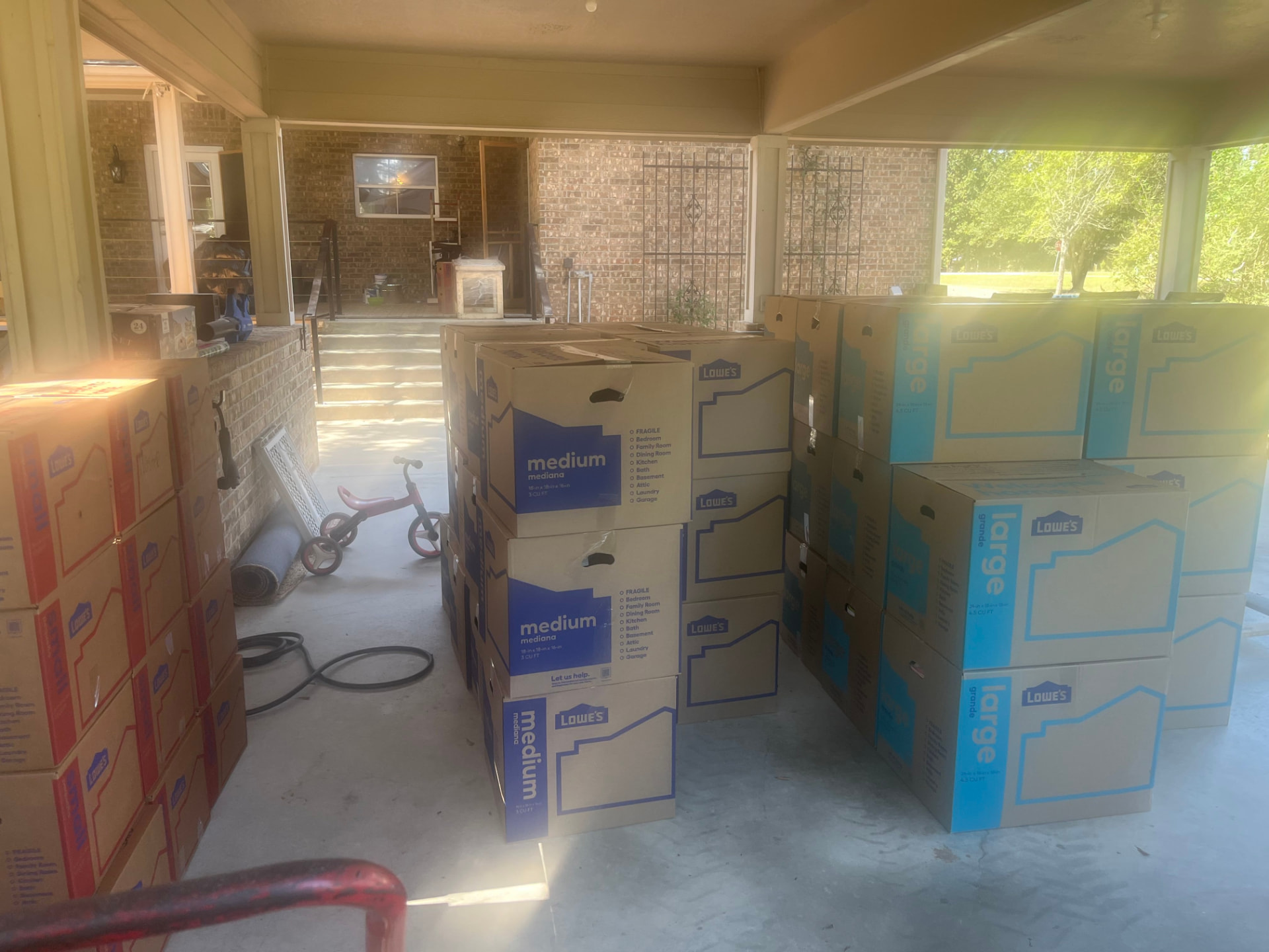 Labeled moving boxes organized by size on a back porch