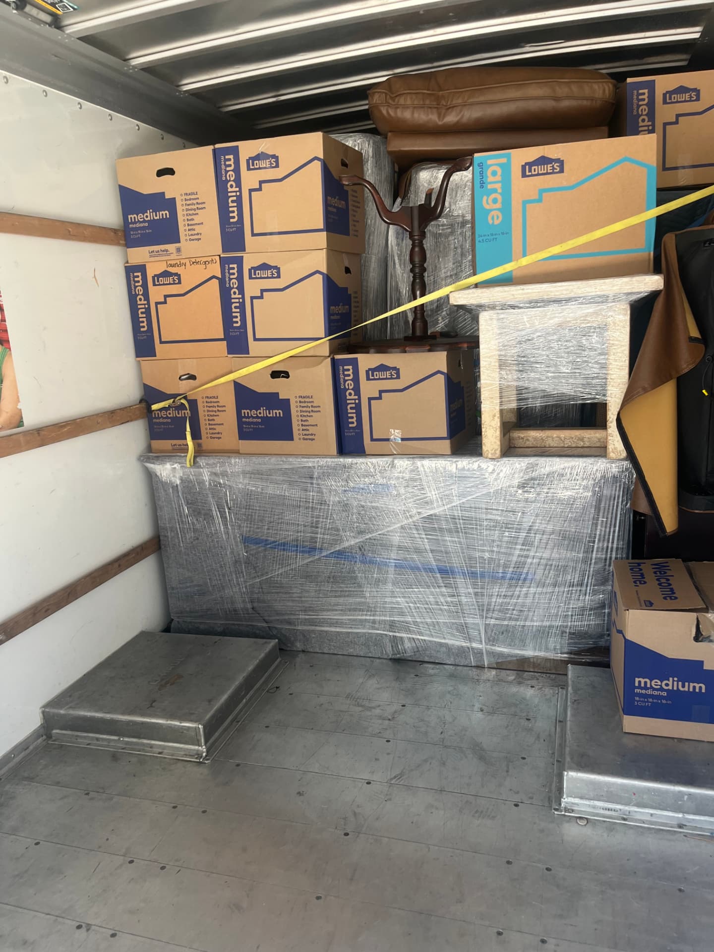 Shrink-wrapped dresser and sofa cushions secured with a strap
